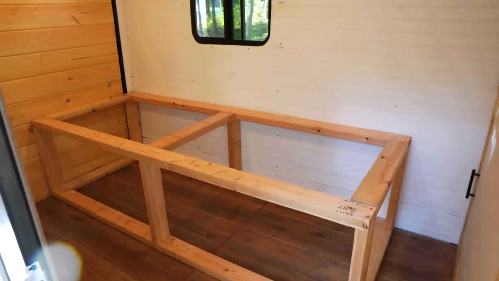2x4 frame of the storage bed box built along one wall of the trailer