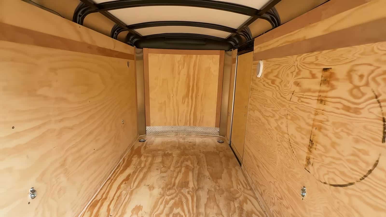 Empty interior of the cargo trailer with factory plywood walls and floor