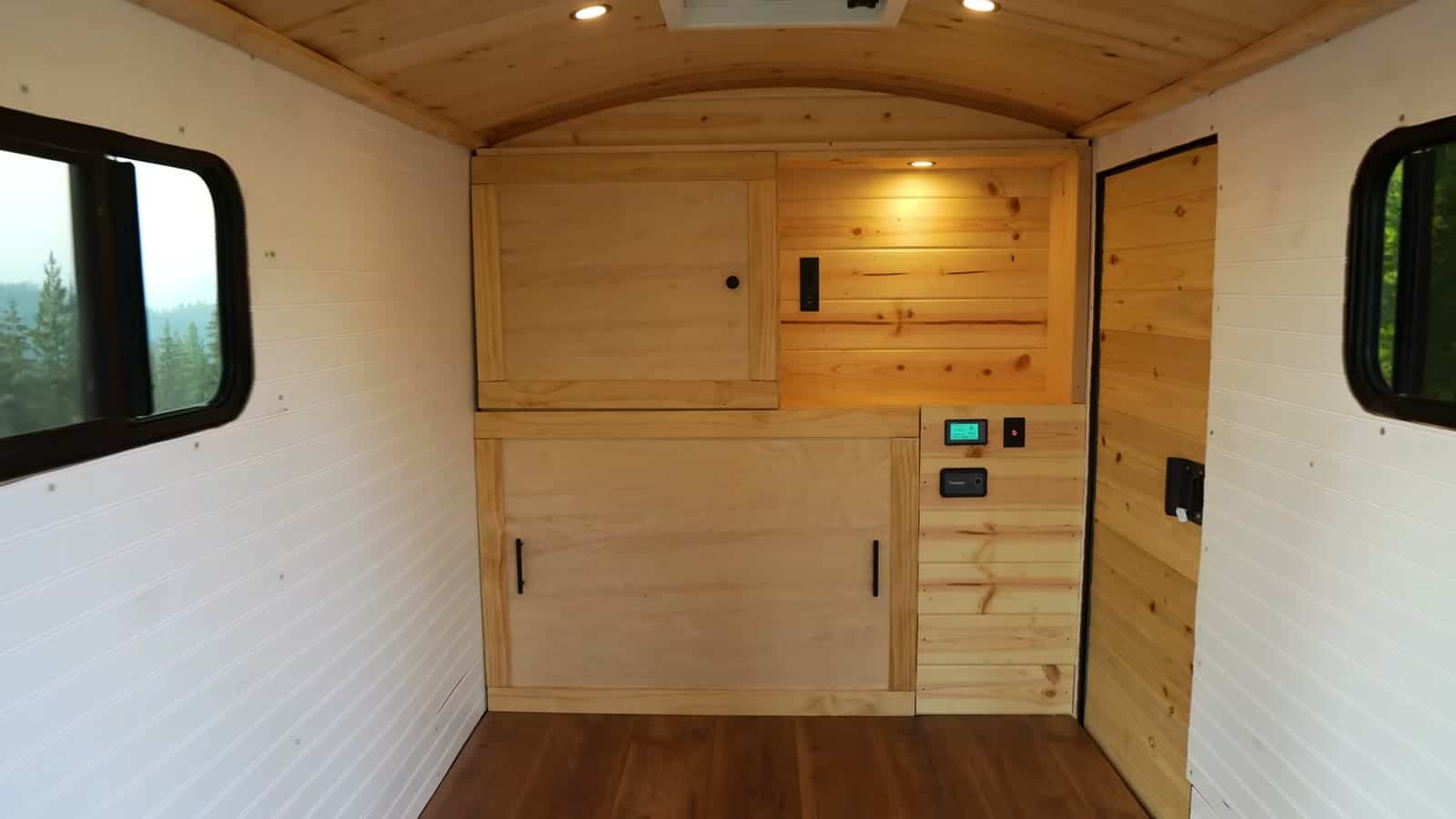 Finished pine cabinet across the front wall with storage doors, open shelf, and control panel