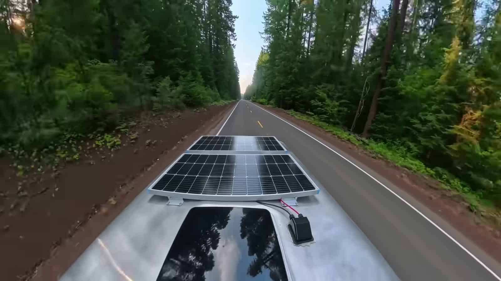 Pickup towing the solar-equipped trailer down a forested Oregon road