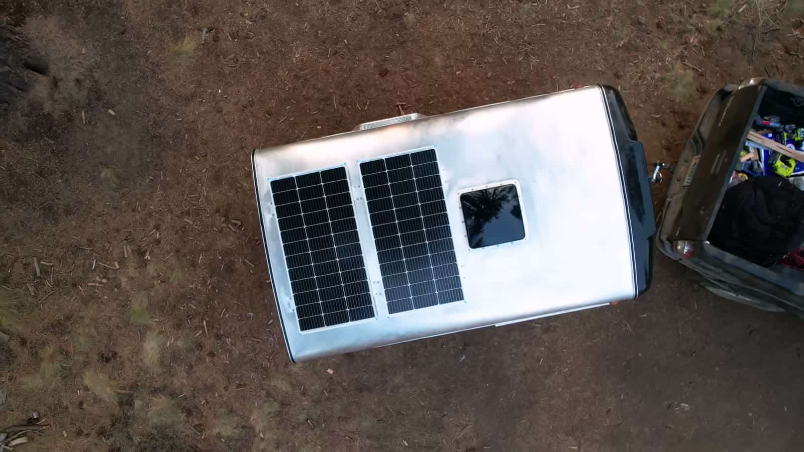 Overhead view of the trailer roof showing two solar panels and the vent fan