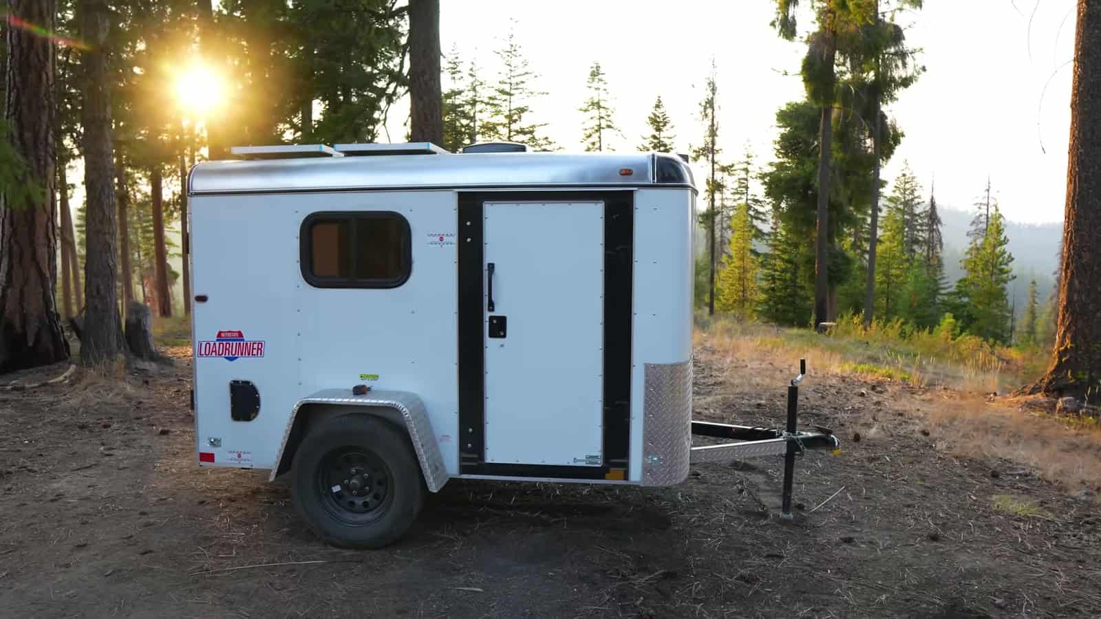 Finished-looking cargo trailer camper at a forest campsite in Washington at sunset