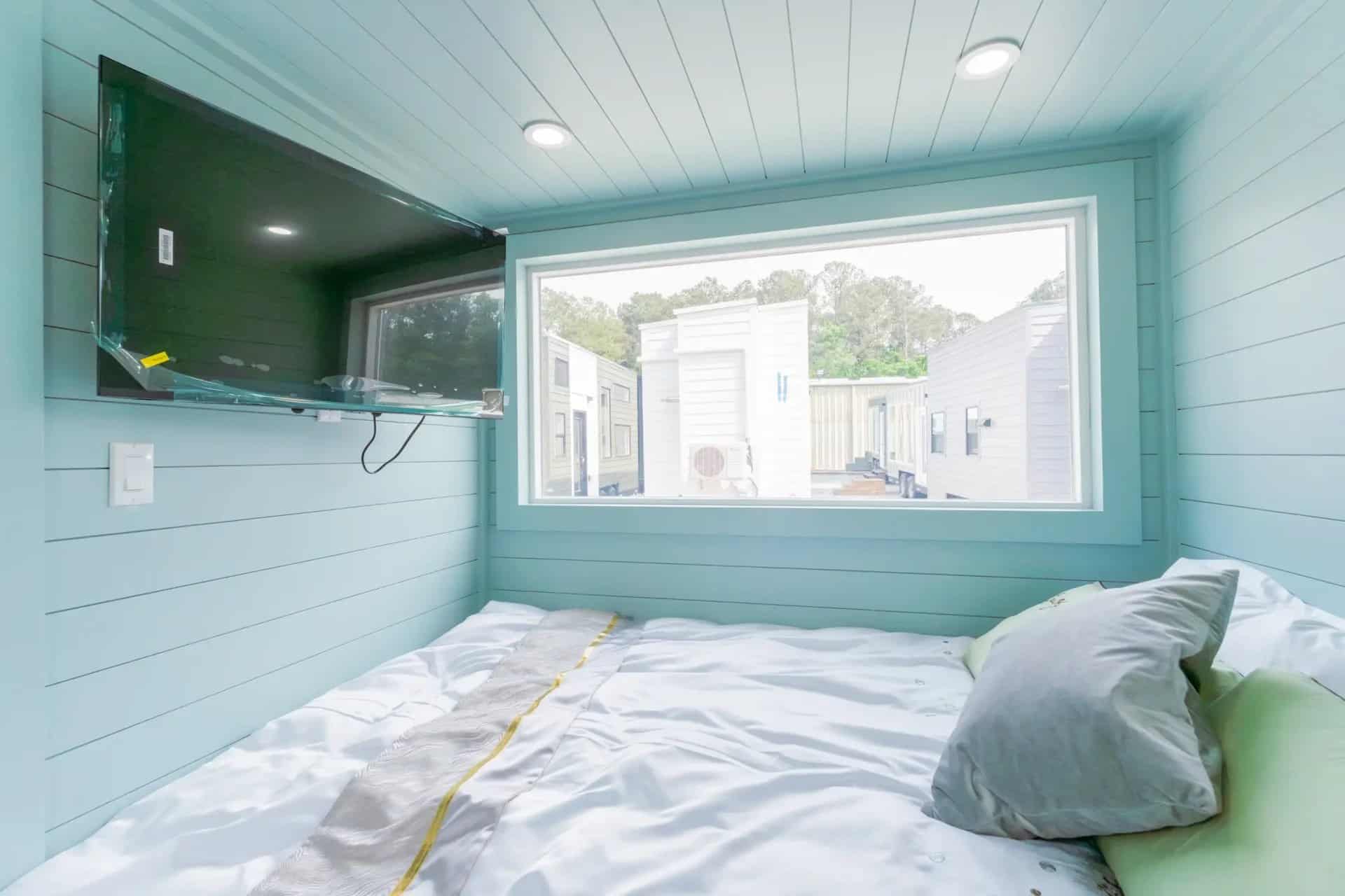 Wall-mounted 43-inch TV and window in the first-floor bedroom of the Avalon 24