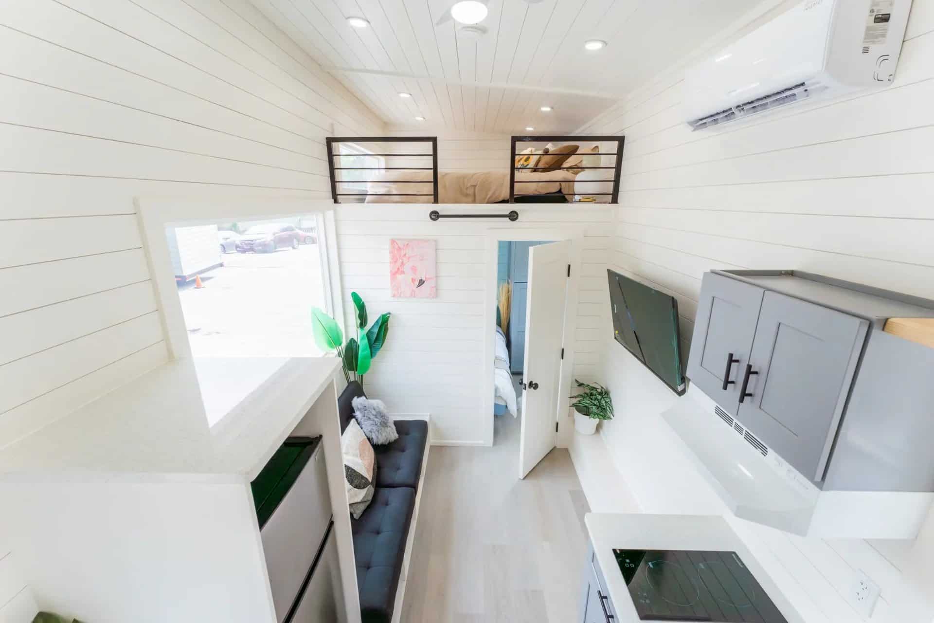 Full-length interior view of the Avalon 24 with kitchen, living area, loft railings and mini-split