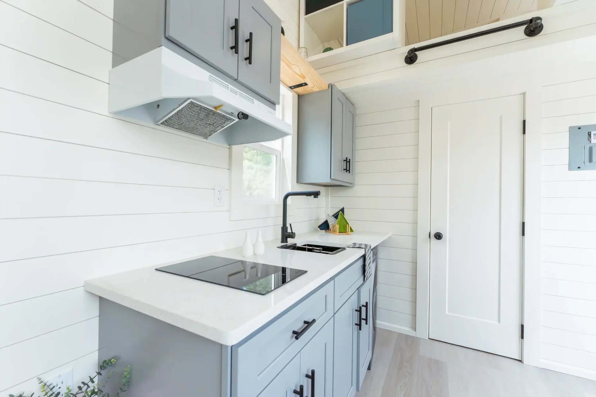 Avalon 24 kitchen with two-burner cooktop, range hood, gray shaker cabinets, and black faucet