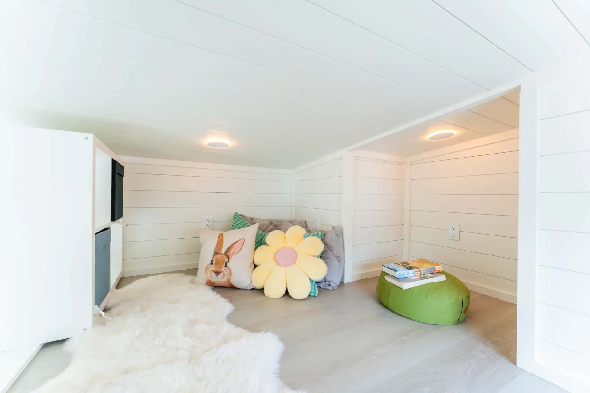 Second loft in the Avalon 24 showing built-in cubby storage and a cozy lounge setup