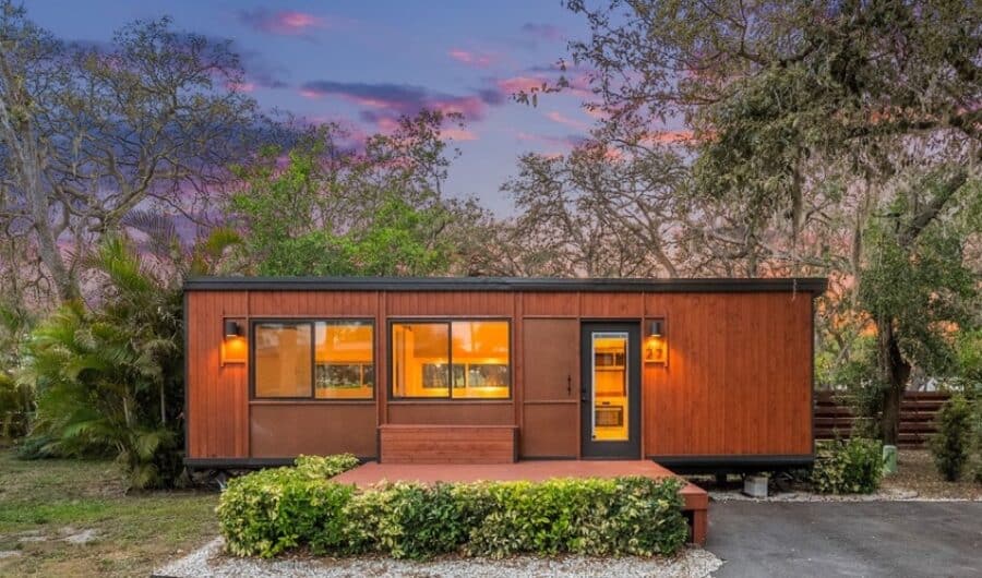 eBoho XL tiny house at dusk with evening lighting in Palm Court