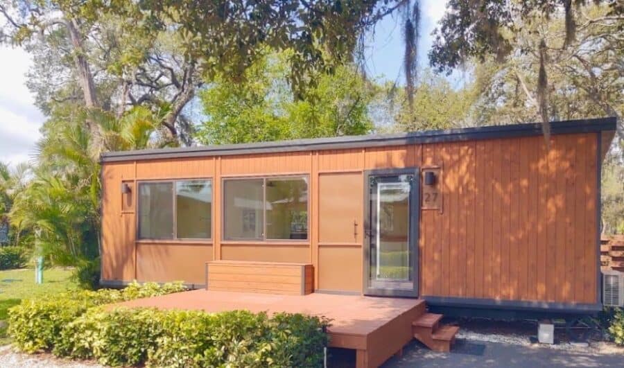 Modern tiny house with wooden exterior and large windows at Palm Court.