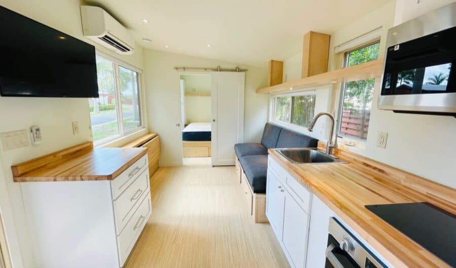 Tiny House Interior with modern kitchen and cozy sleeping area.