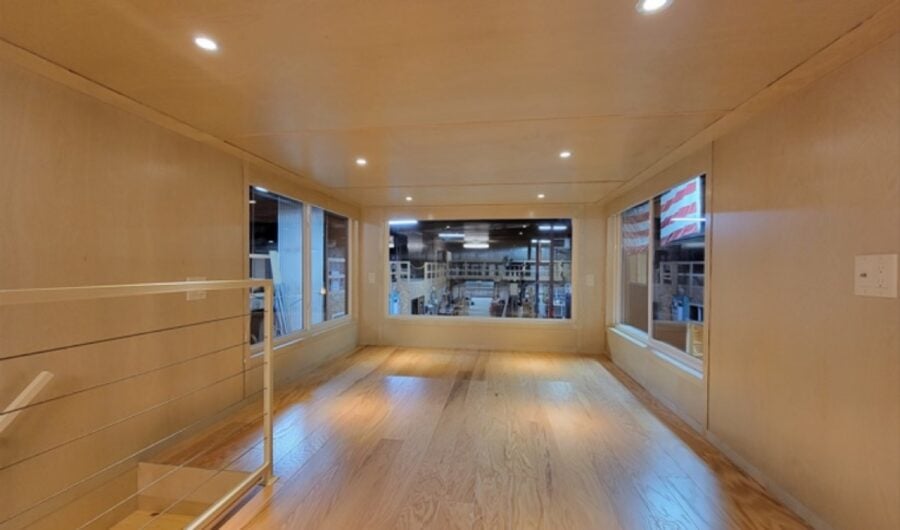Bright interior of a tiny house showcasing spacious living area and expansive windows for natural li.