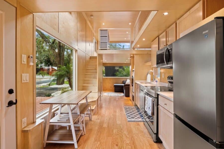 Cozy tiny house kitchen with modern appliances and natural wood finishes.