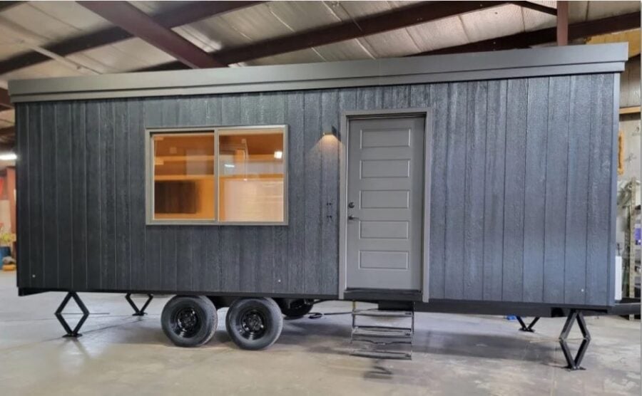 EVista tiny house on wheels with sleek gray exterior and small porch.
