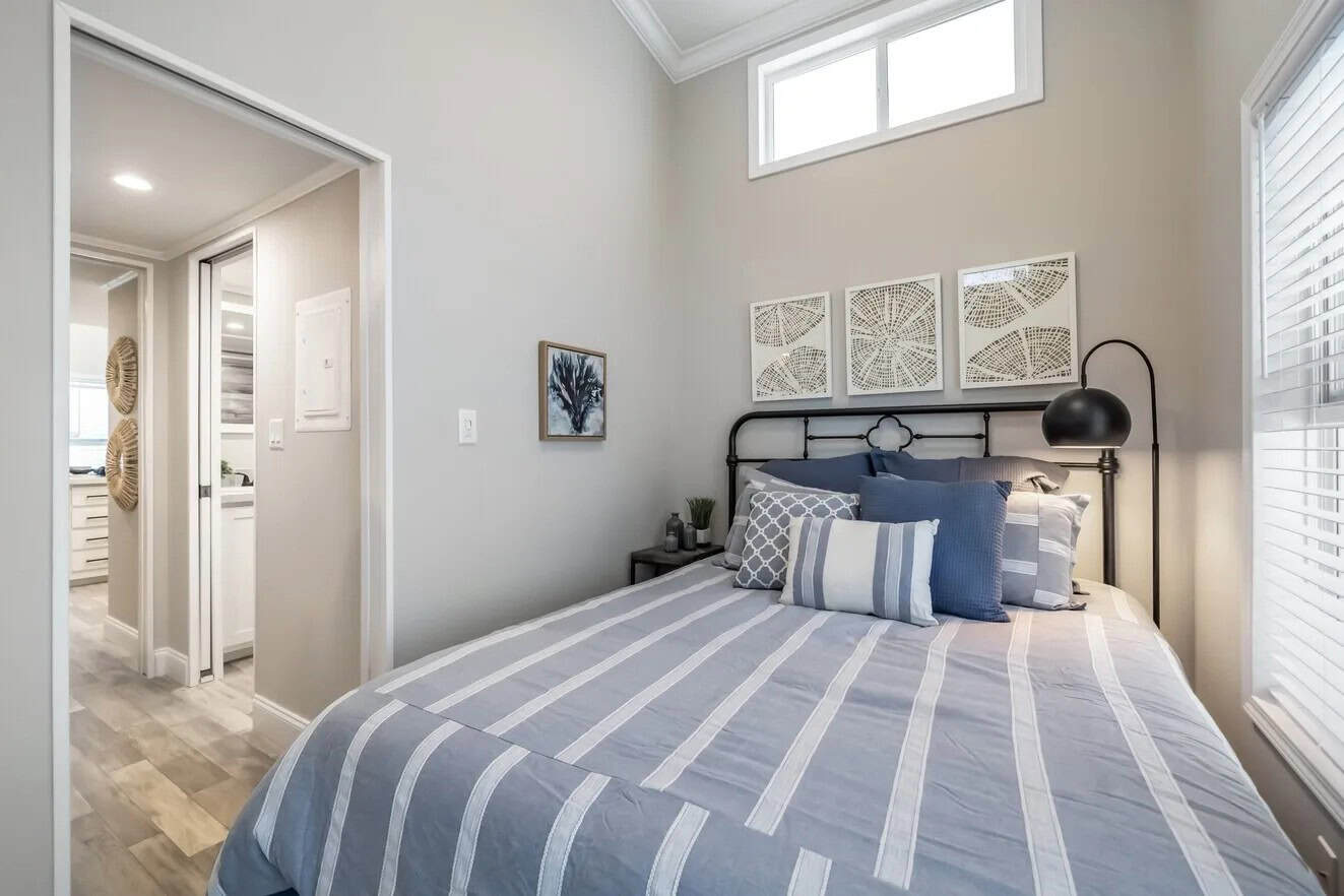 Bedroom with a bed, a window, and a doorway to a hall