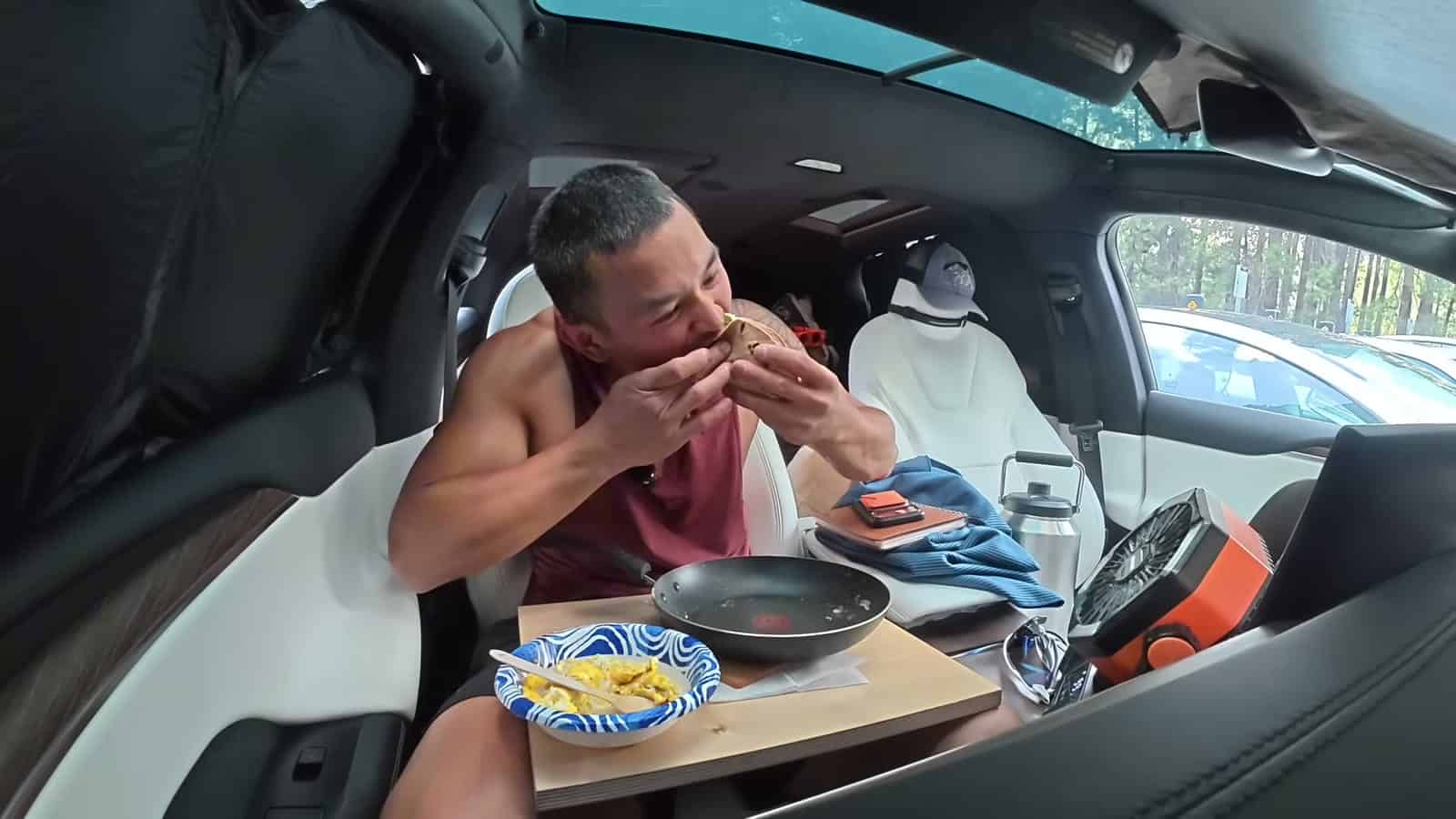 Nico Murillo eating a meal inside his air-conditioned Tesla Model X