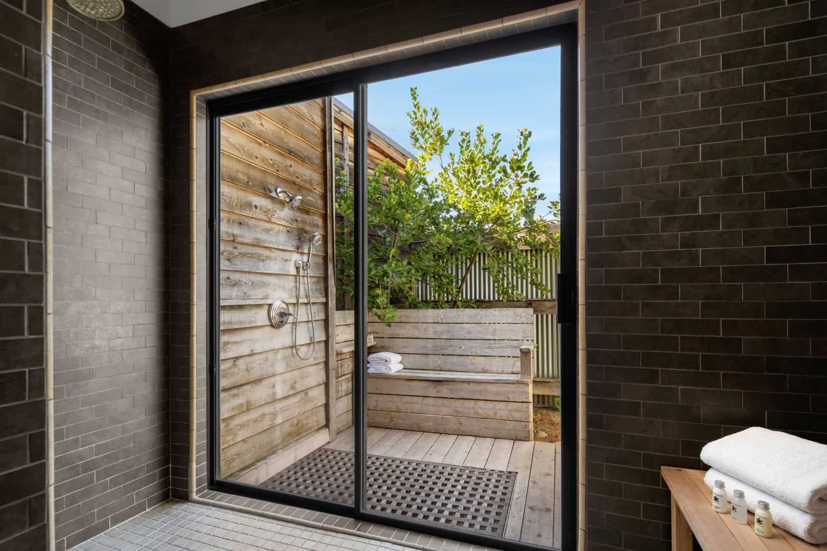 Shower opening onto a wood bench outside