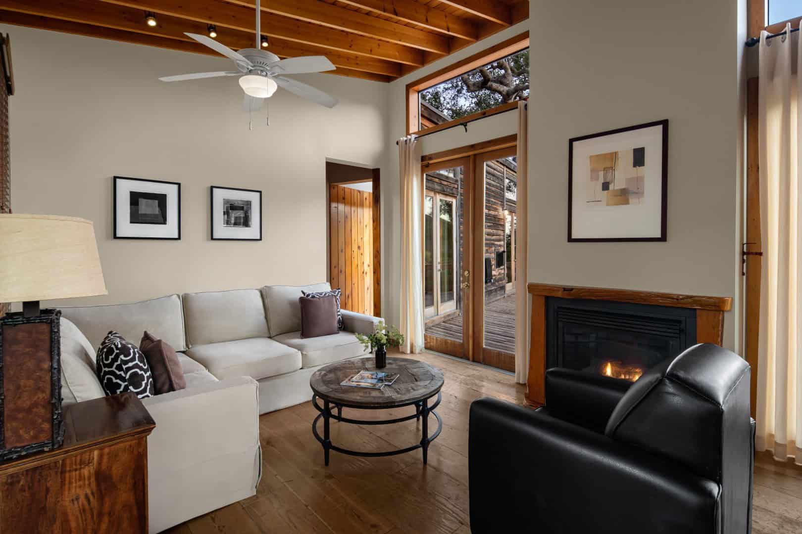 Sitting room with a sofa, a chair, and doors to a wood exterior