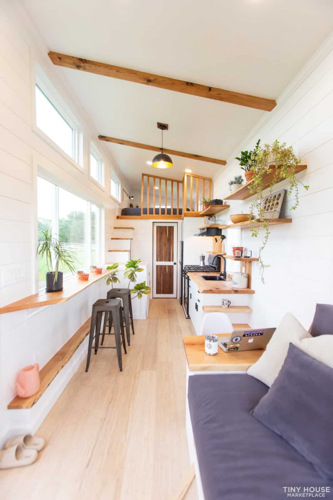Bright tiny house interior with large windows and minimalist decor.
