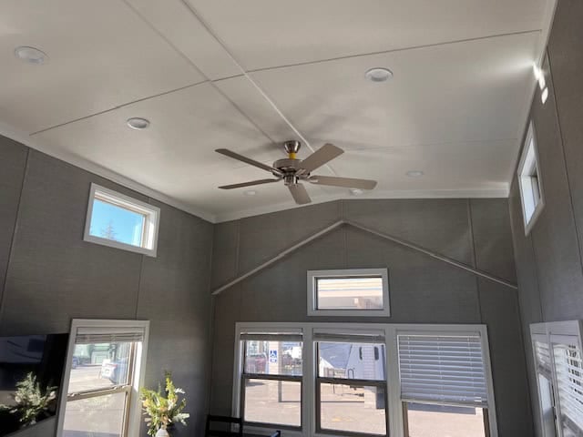 Vaulted ceiling with a ceiling fan and clerestory windows over the living area