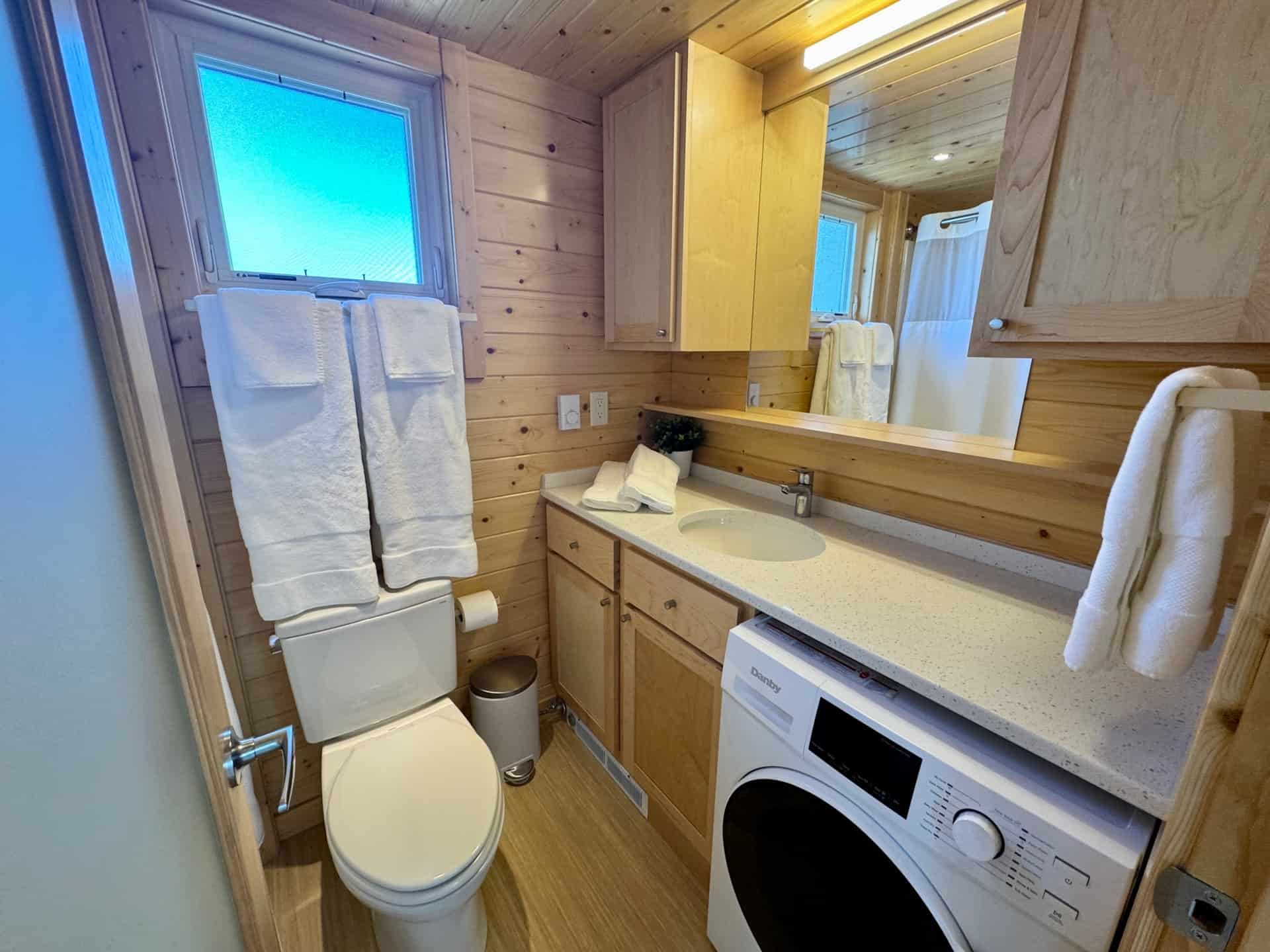 Full bathroom with vanity and washer dryer in the Escape Boho XL tiny house