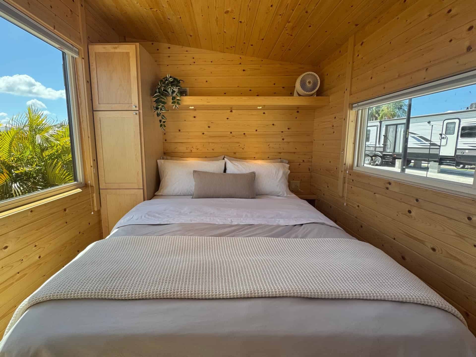 Main-floor queen bedroom with windows in the Escape Boho XL tiny house