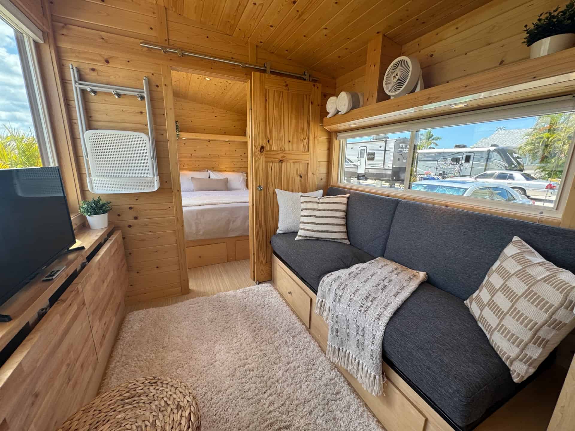Living area with built-in sofa and TV in the Escape Boho XL tiny house