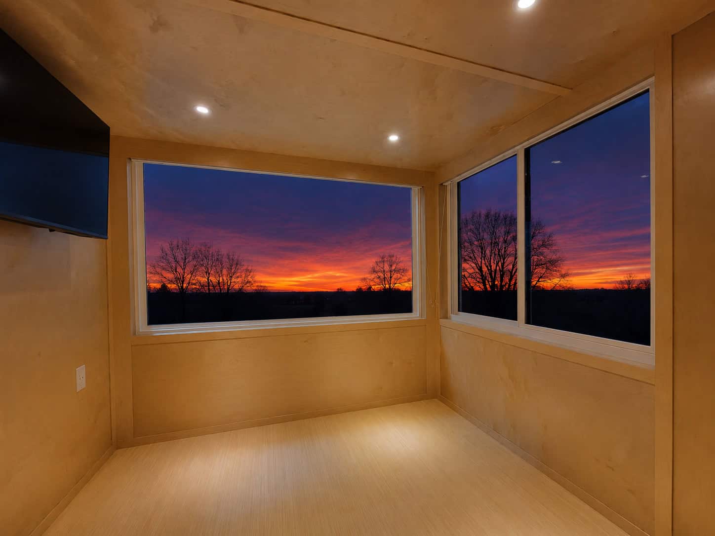 Escape eONE Limited living area with large corner windows framing a sunset view