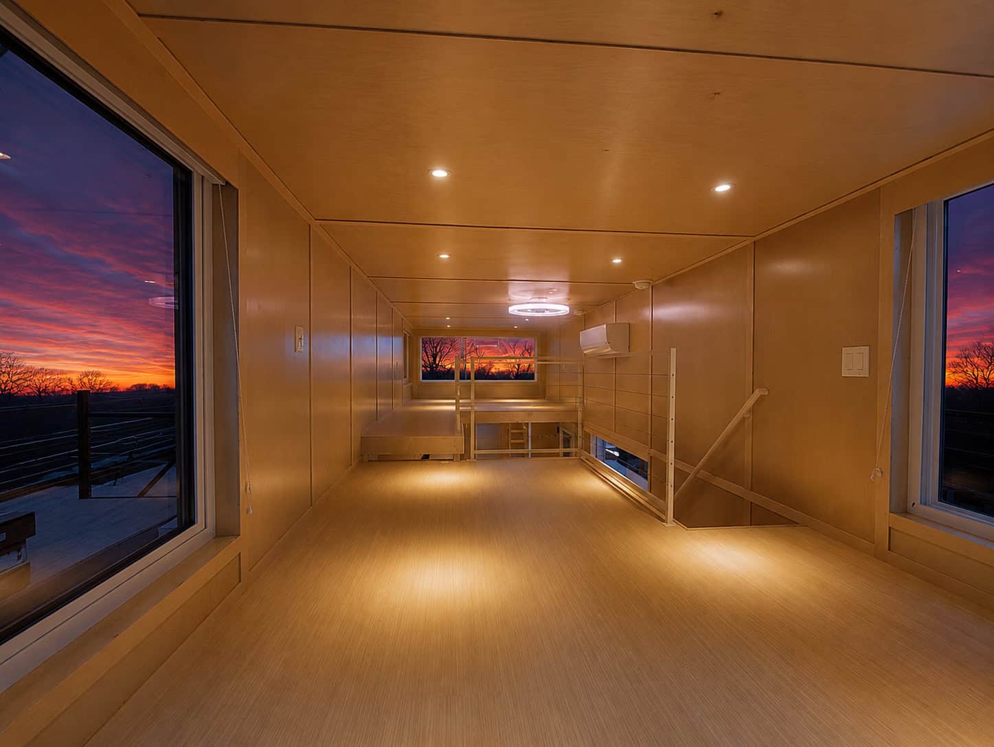 Wide view of the Escape eONE Limited upper floor showing floor-to-ceiling glass on both ends and modern cable railing
