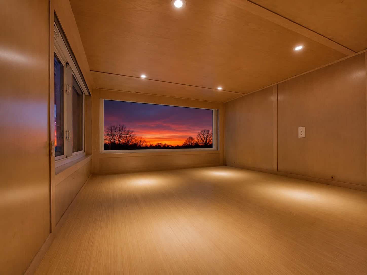 Escape eONE Limited upper floor room with a large picture window framing a sunset view