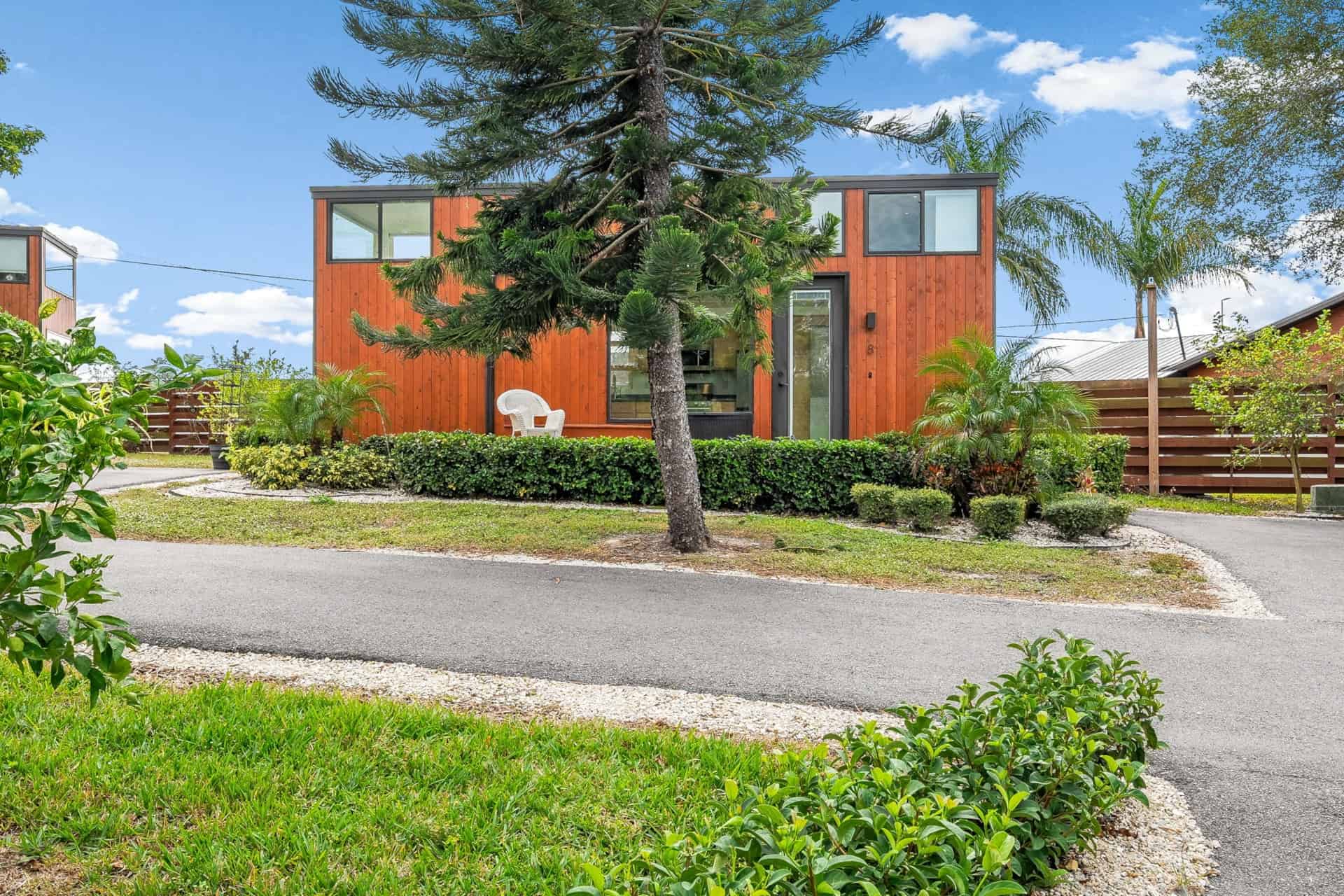 Escape One XL tiny home exterior with wood siding and landscaping in Tampa Bay
