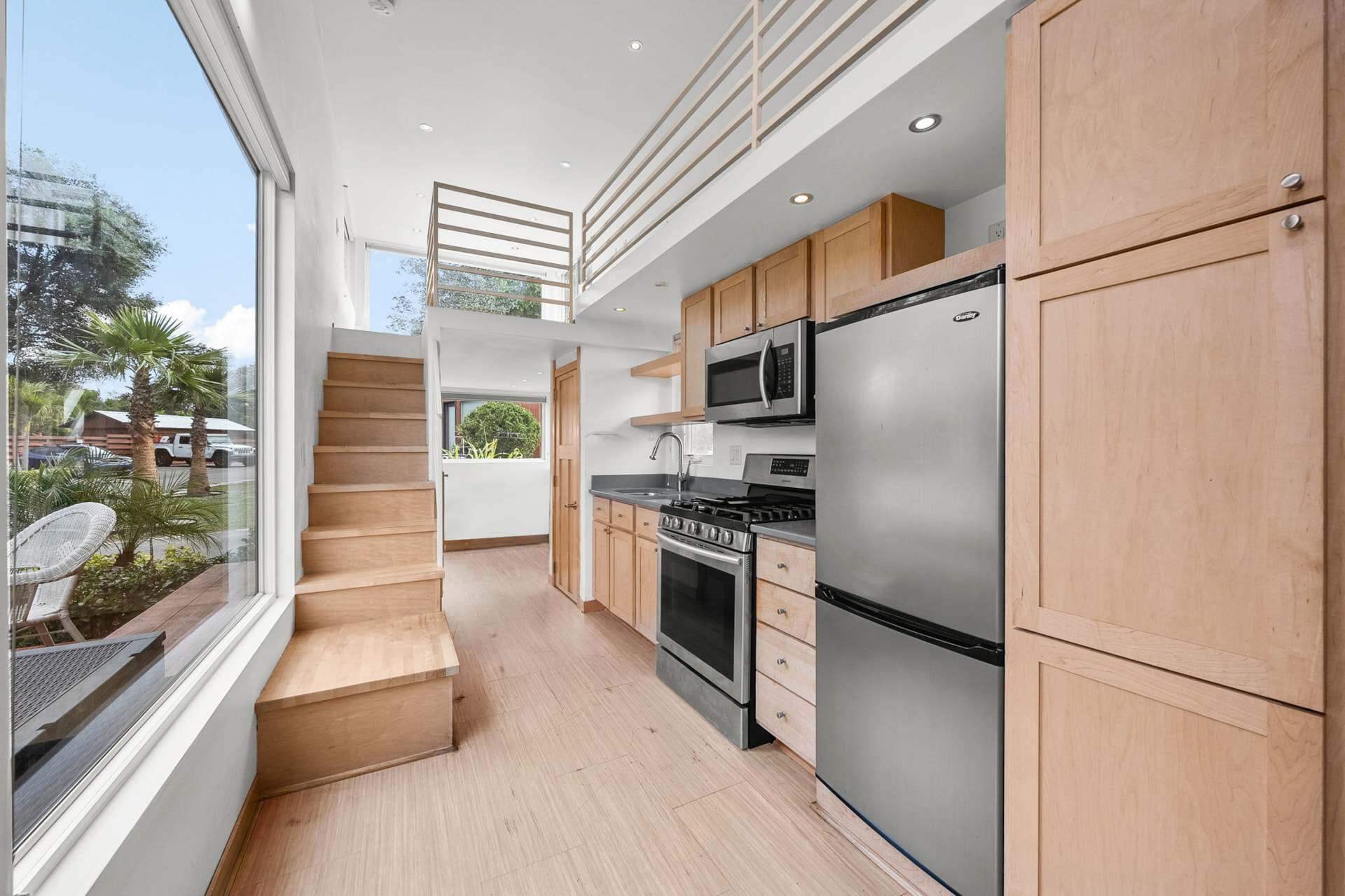 Bright open two-story interior of the Escape One XL tiny home with staircase