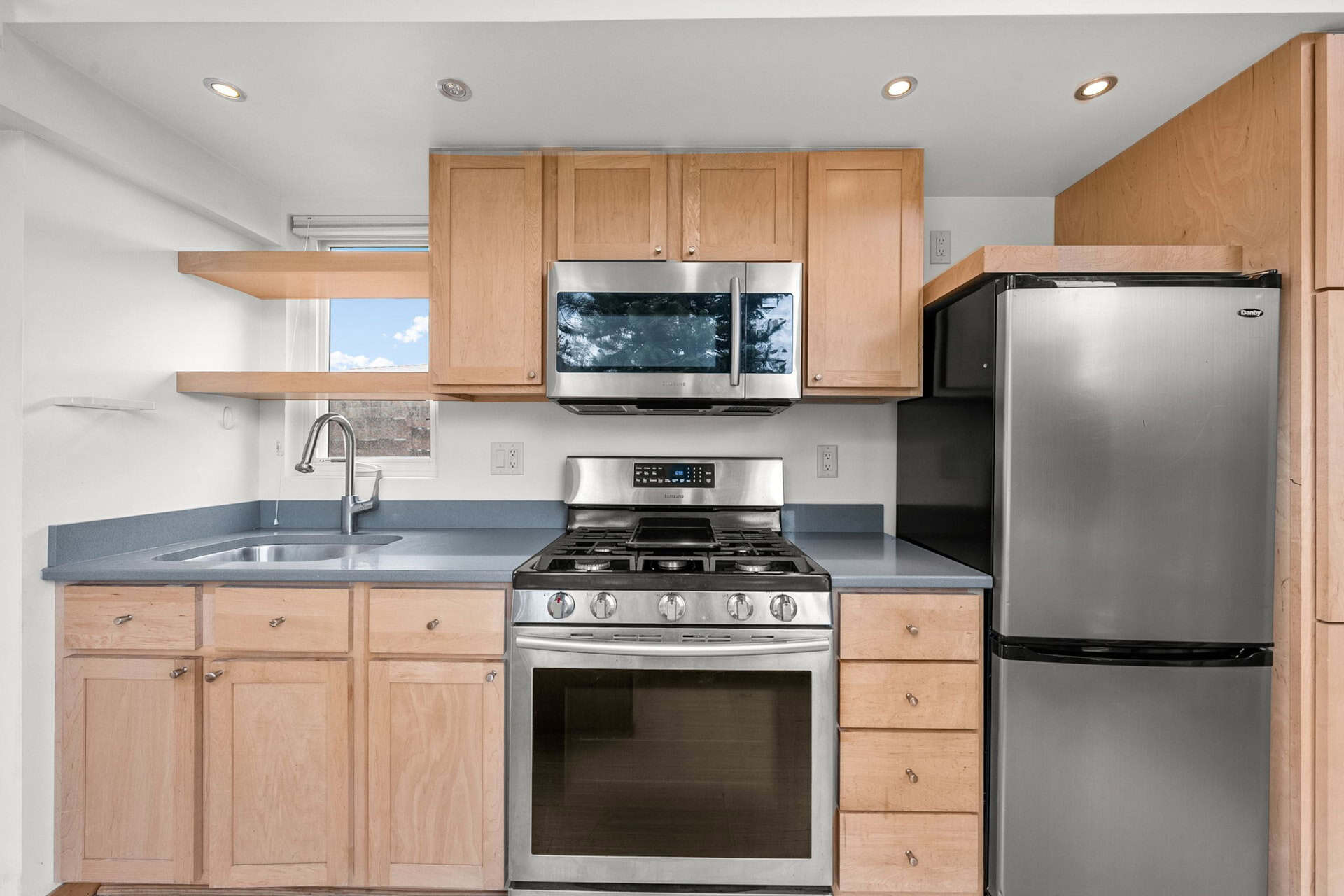 Escape One XL kitchen with gas range, maple cabinets, and stone counters