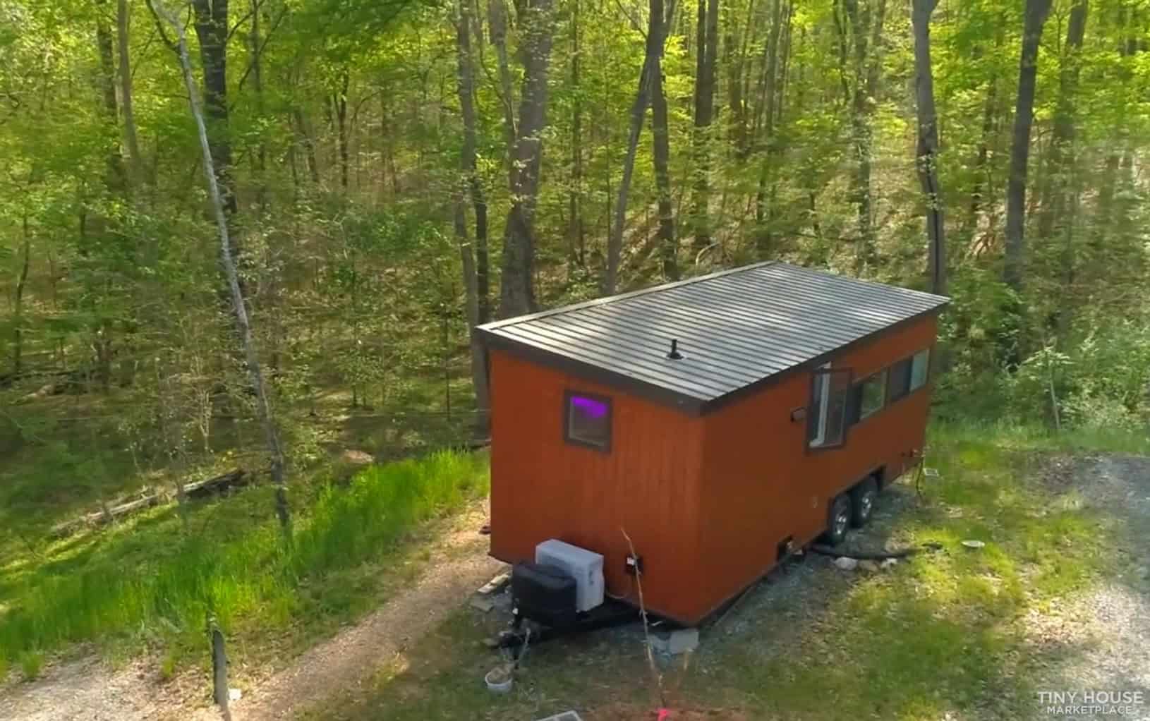 Aerial view of the Escape Vista Boho tiny house on a tandem axle trailer in the woods