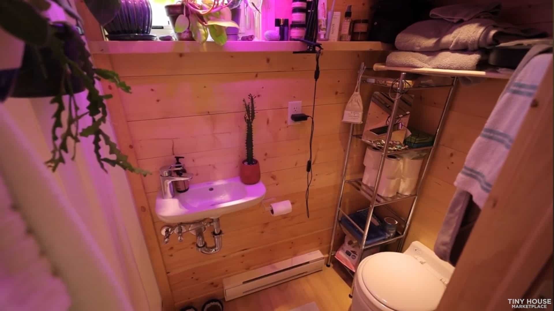 Escape Vista Boho bathroom with a wall-mounted sink, composting toilet and plants on the window ledge