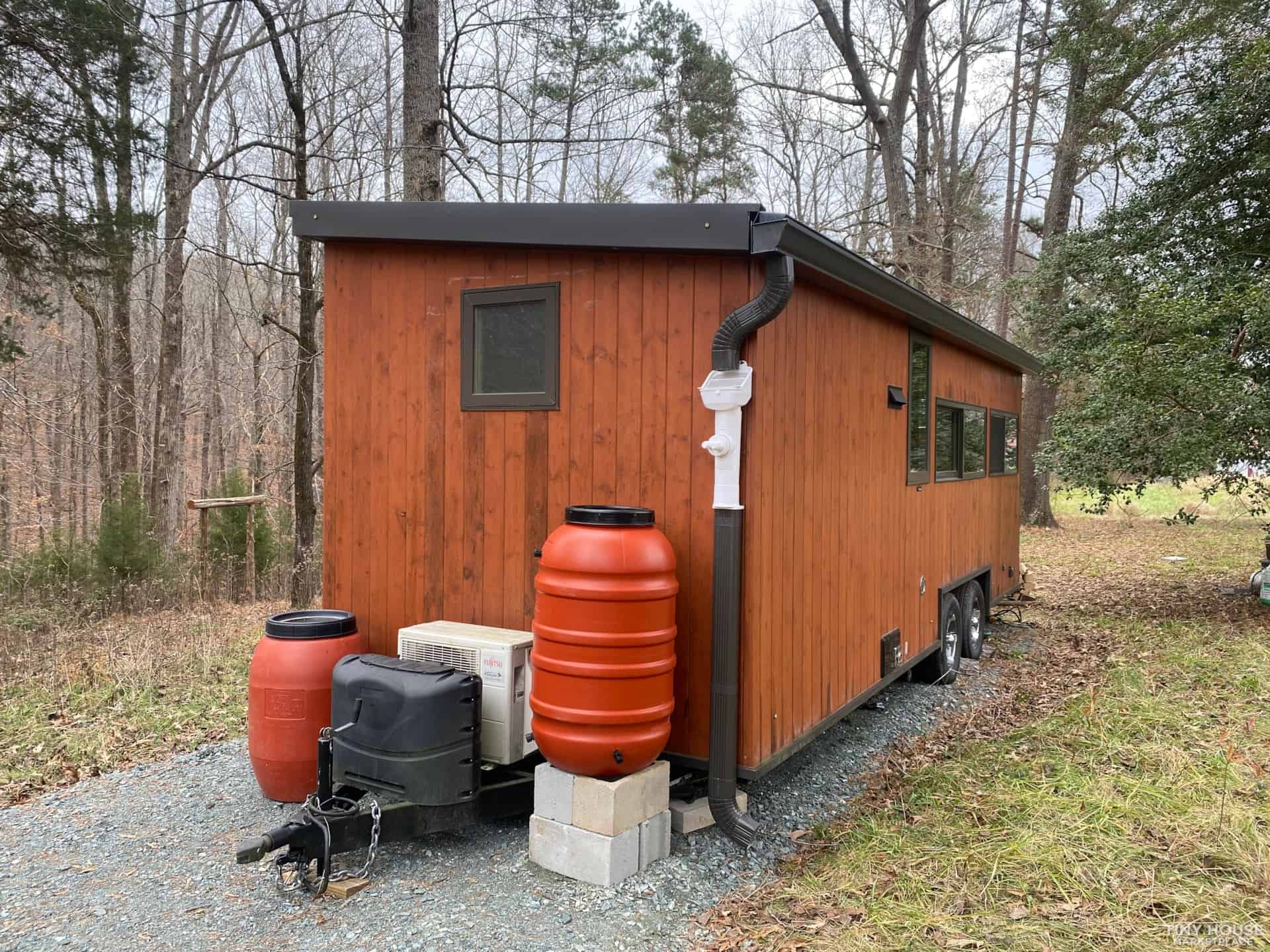 Escape Vista Boho with gutters feeding orange rain barrels and a first flush diverter