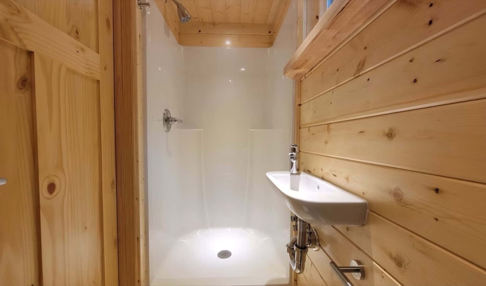Full bathroom shower and sink in the eVista King Limited tiny house