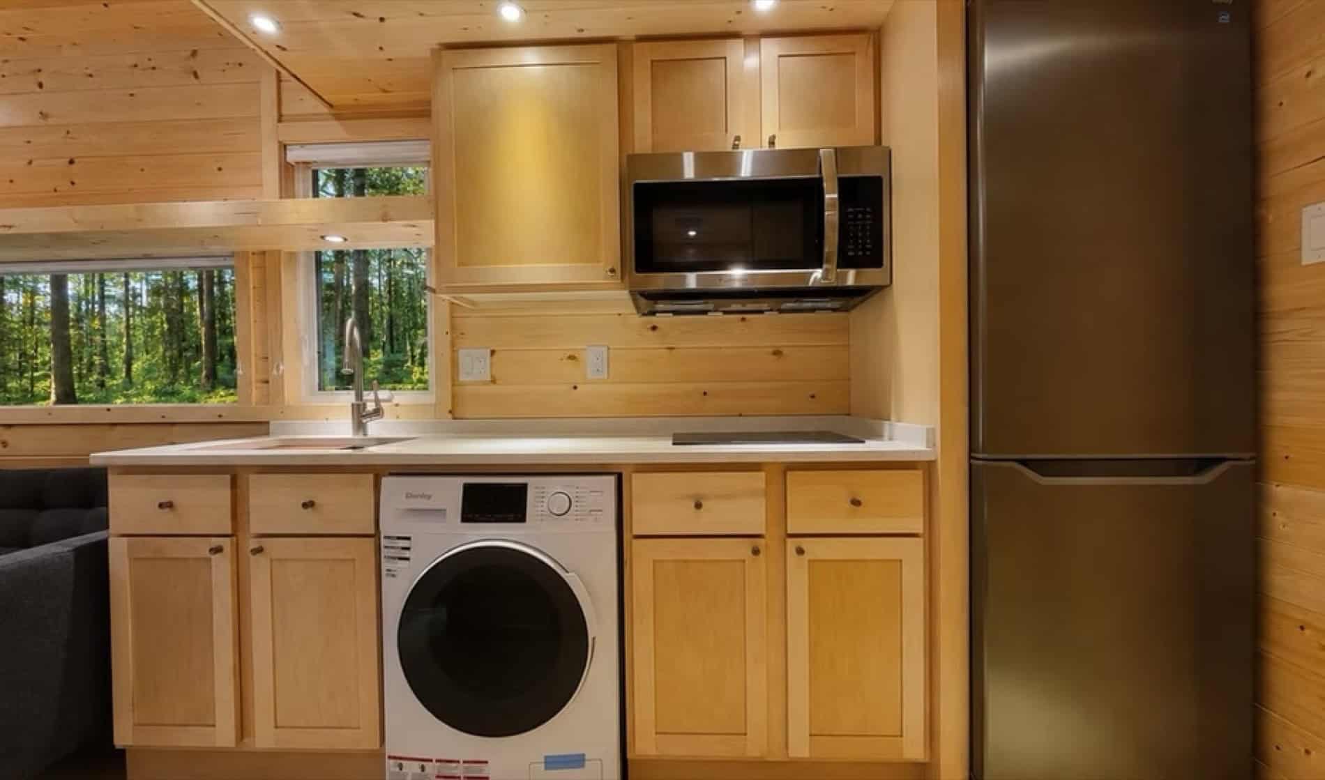 Kitchen with stainless appliances and washer dryer in the eVista King Limited tiny house