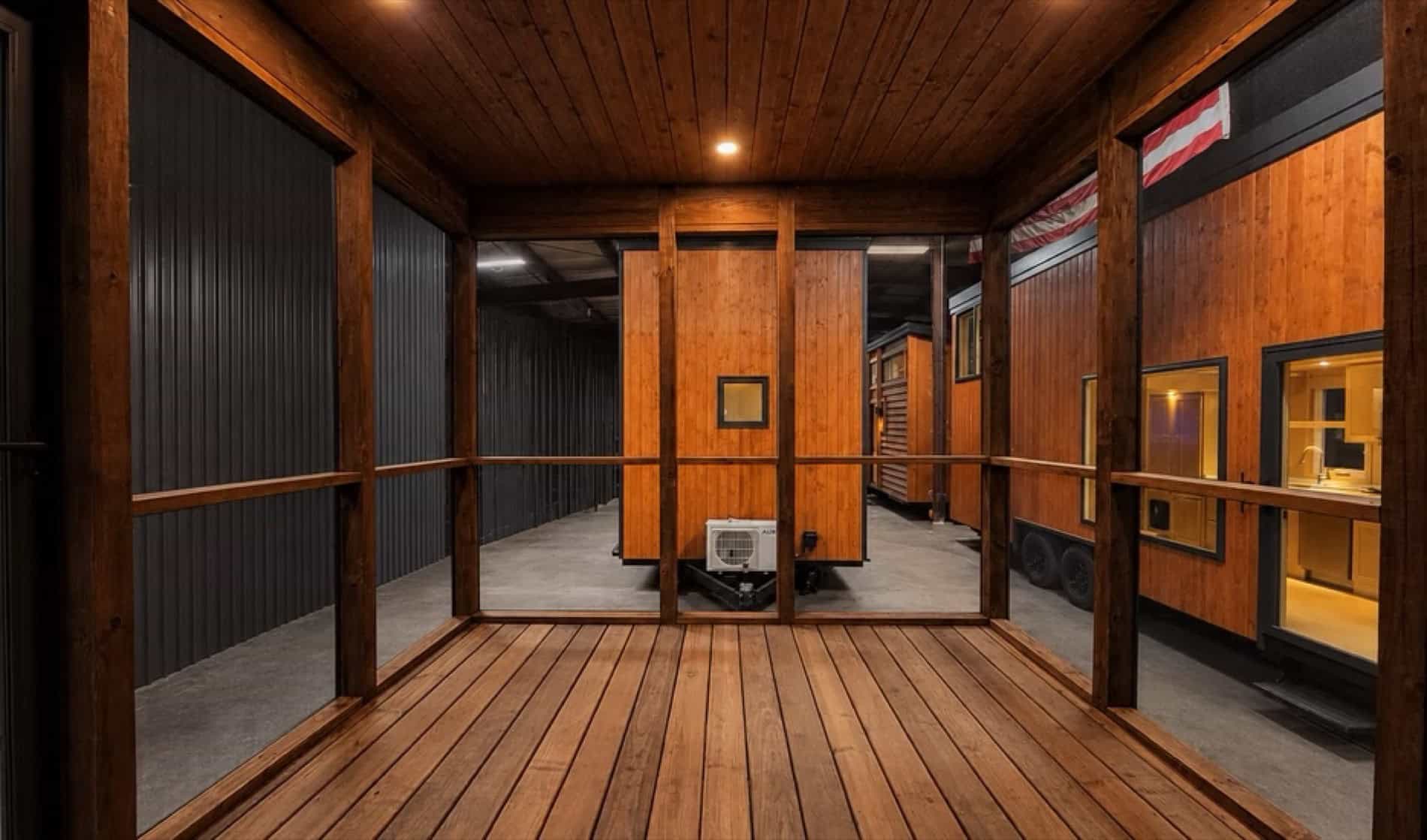 Screened porch of the eVista King Limited tiny house with wood decking and beams