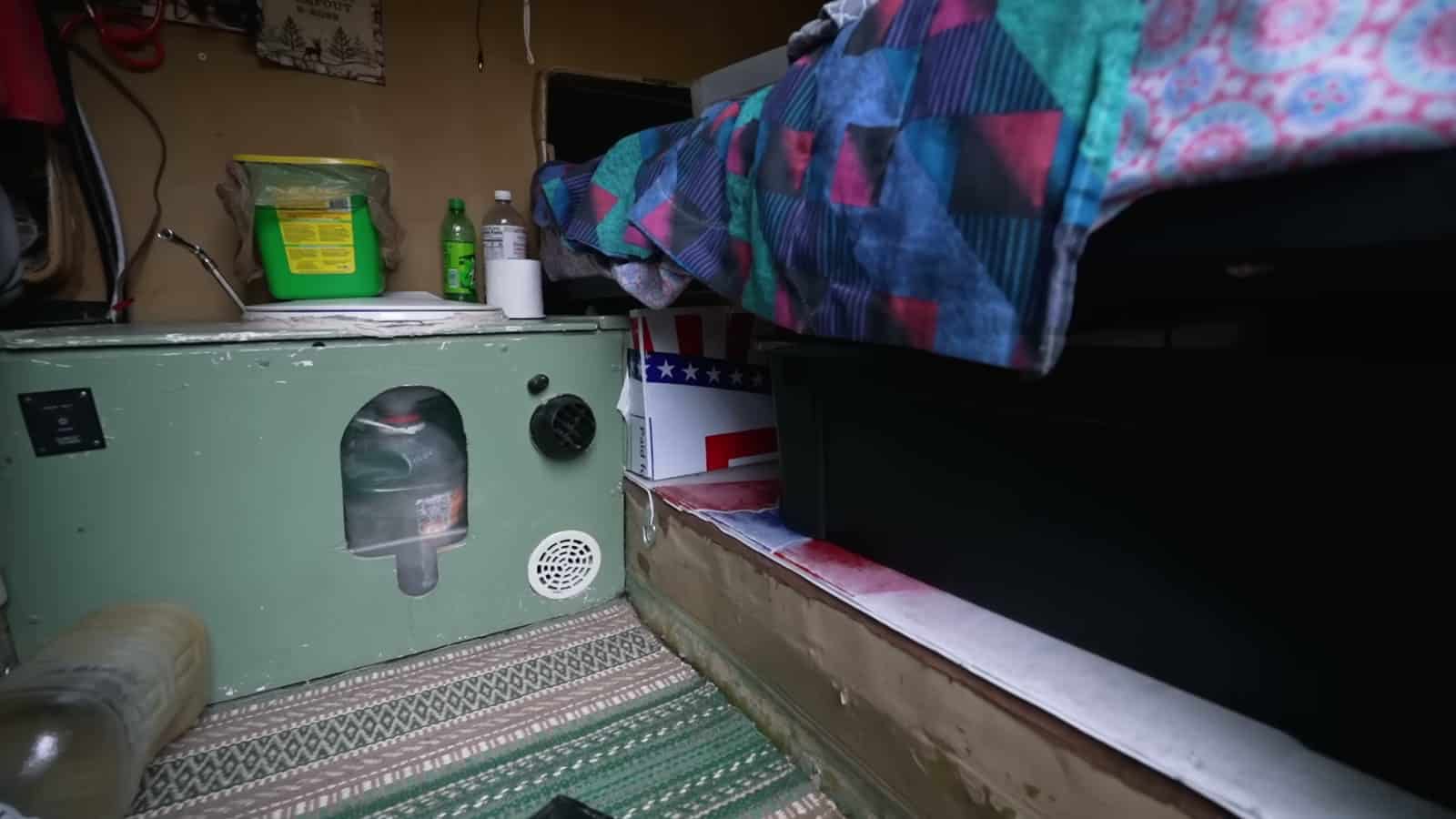 Composting toilet with storage bins under the bed in a foam teardrop trailer