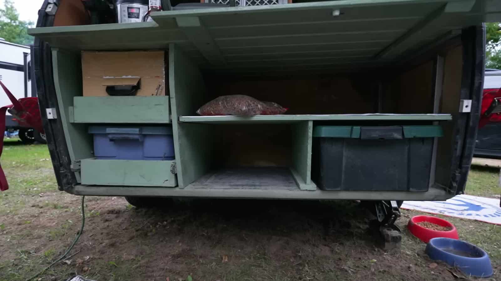 Galley shelves and storage bins in the back of a foam teardrop trailer
