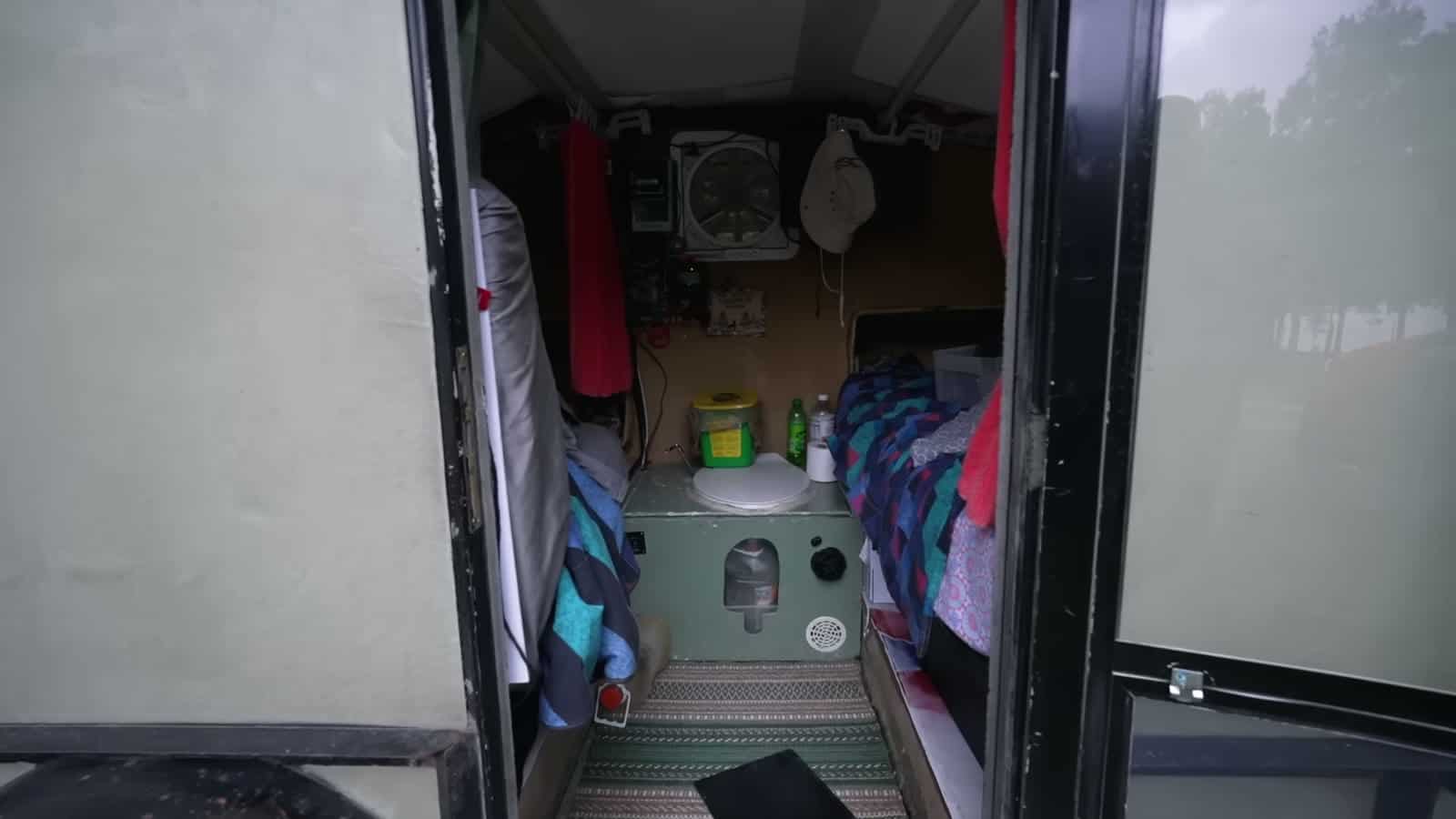 View through the door of a foam teardrop trailer showing the drop floor and composting toilet