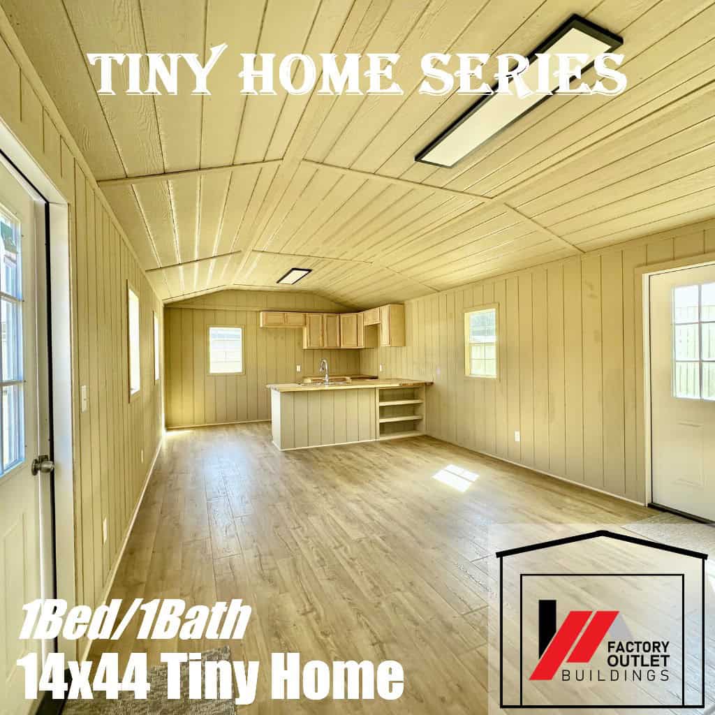 Open living area with light wood paneling looking back to a corner kitchen