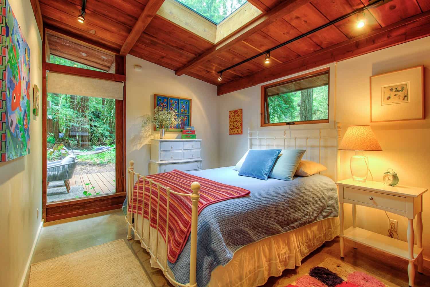 Second bedroom with queen bed, skylight, and windows to the garden