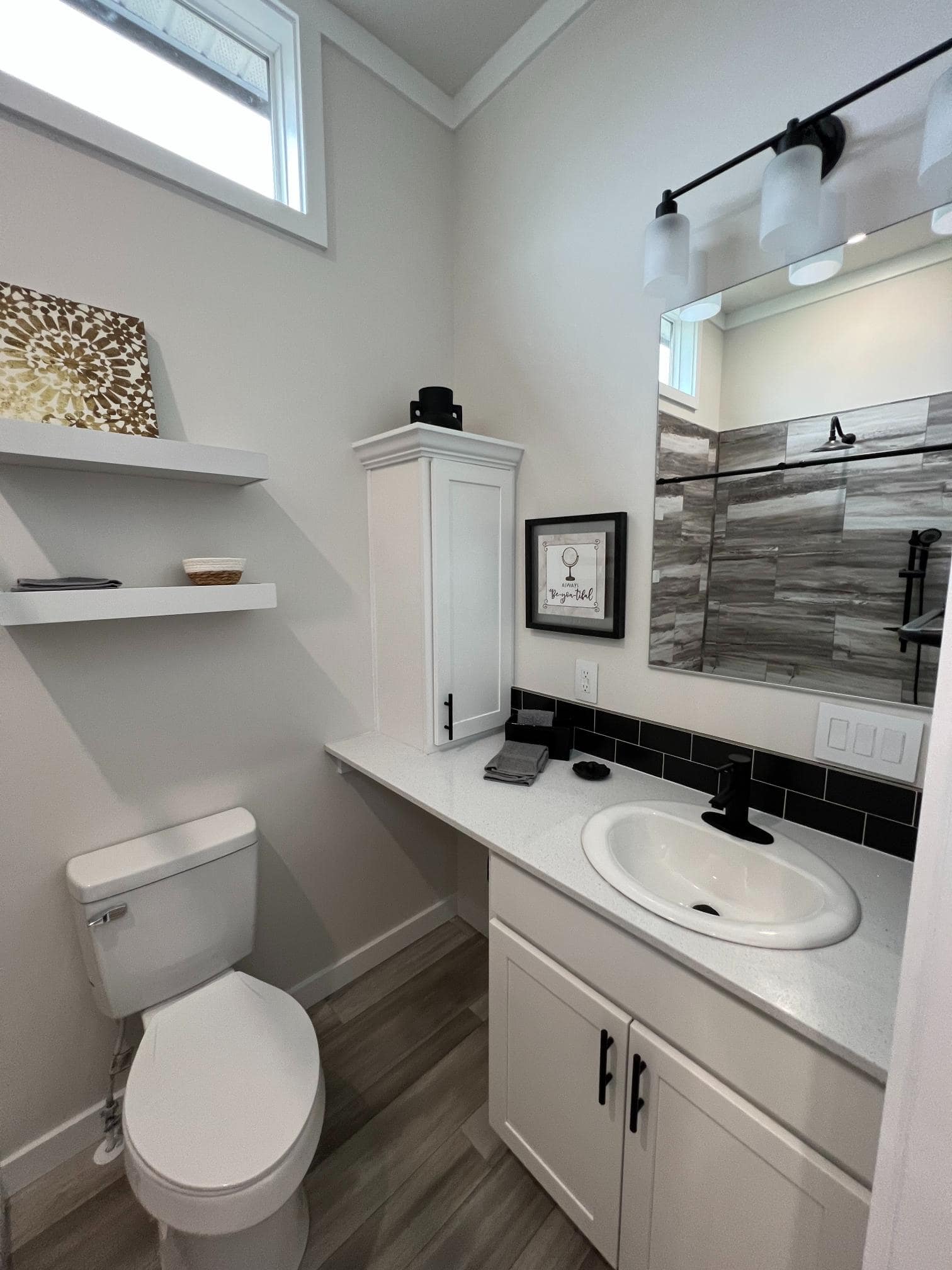 Bayview 300 bathroom with white vanity, floating shelves, and toilet