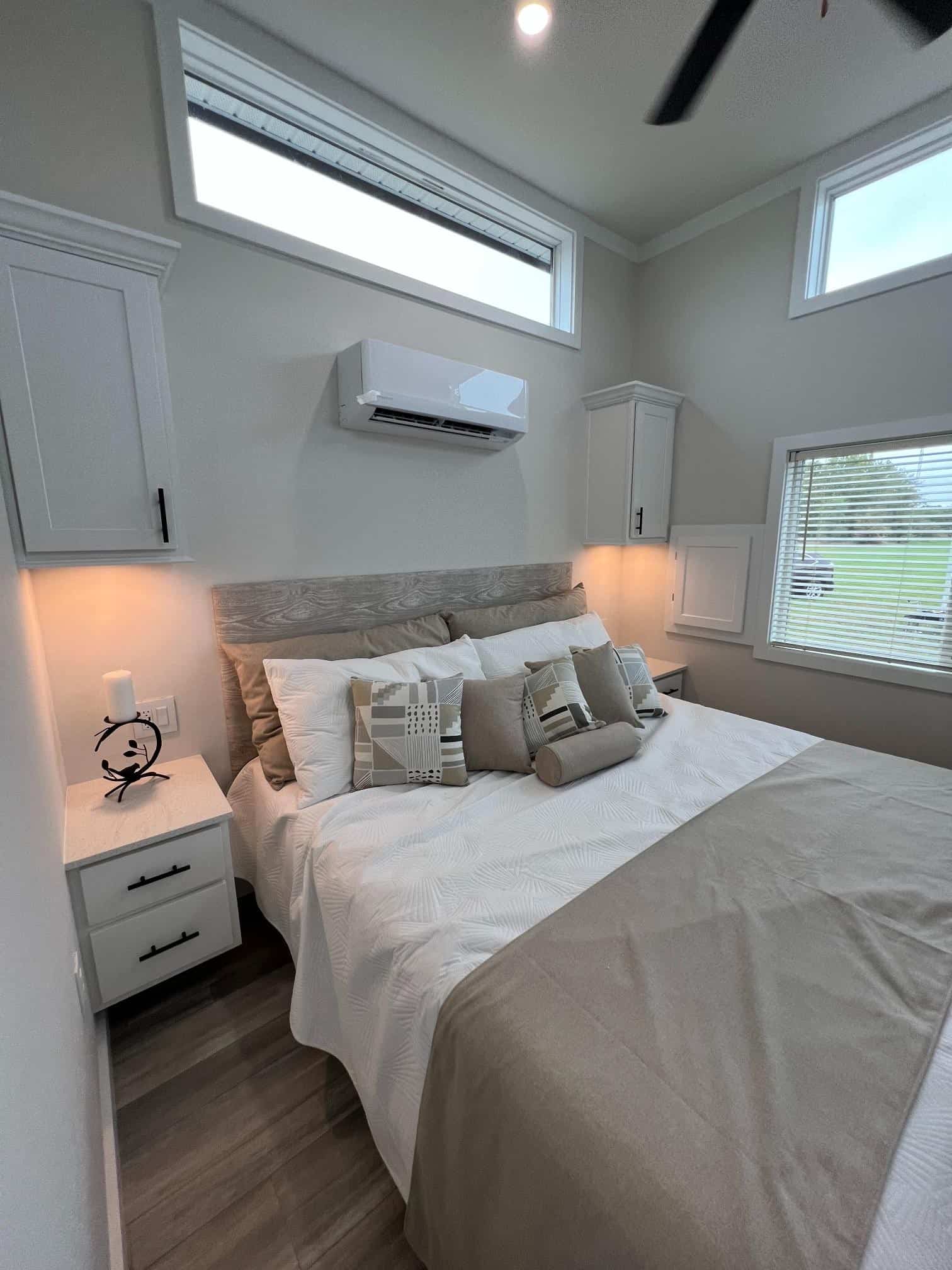 Bayview 300 bedroom: king bed, white built-in nightstands and upper cabinets, mini-split above the headboard