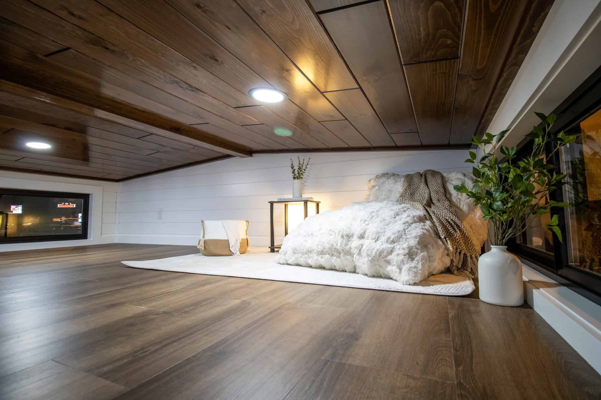 Loft nook: dark wood ceiling, white shiplap, floor cushion and clerestory window