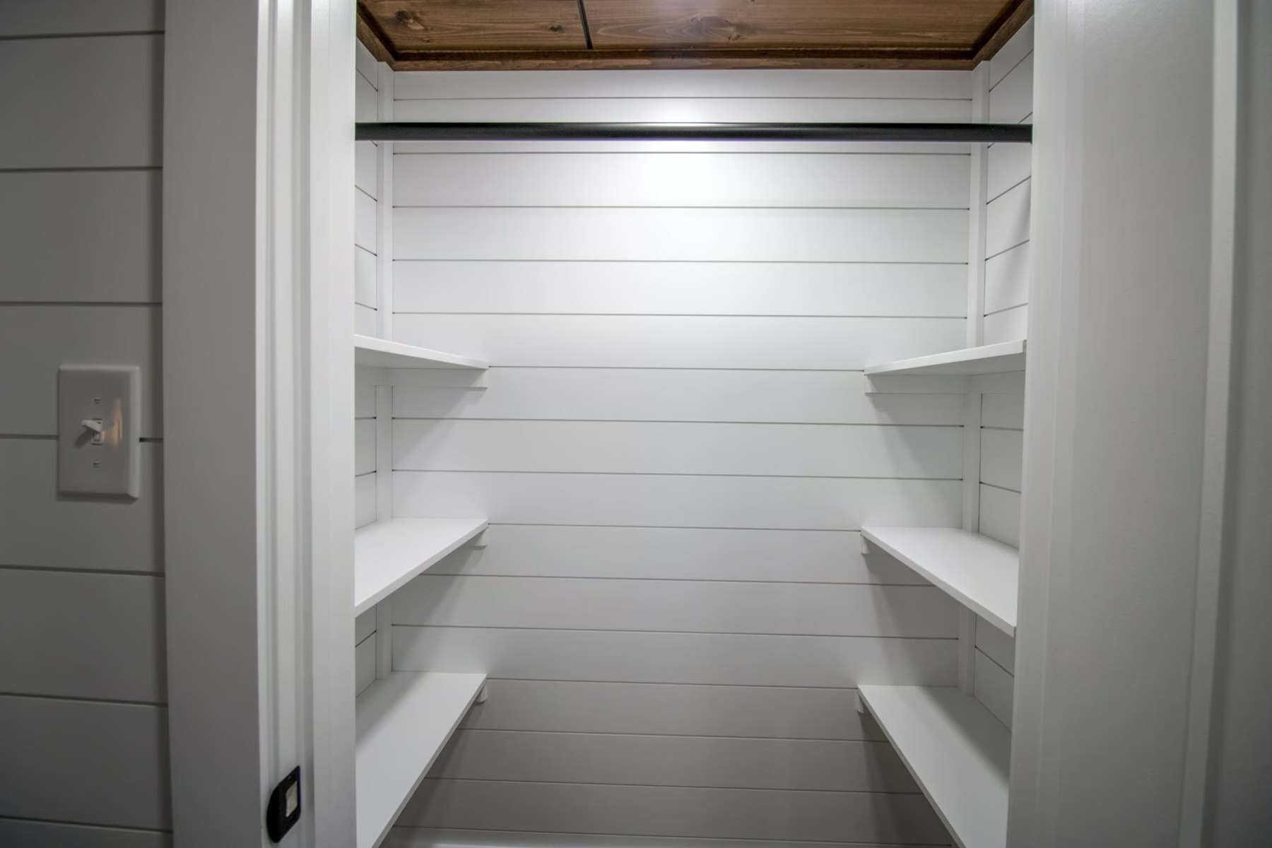 Walk-in pantry closet with white built-in shelves
