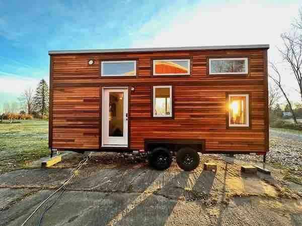A wood-sided tiny house on a dual-axle trailer from Hammerstone School