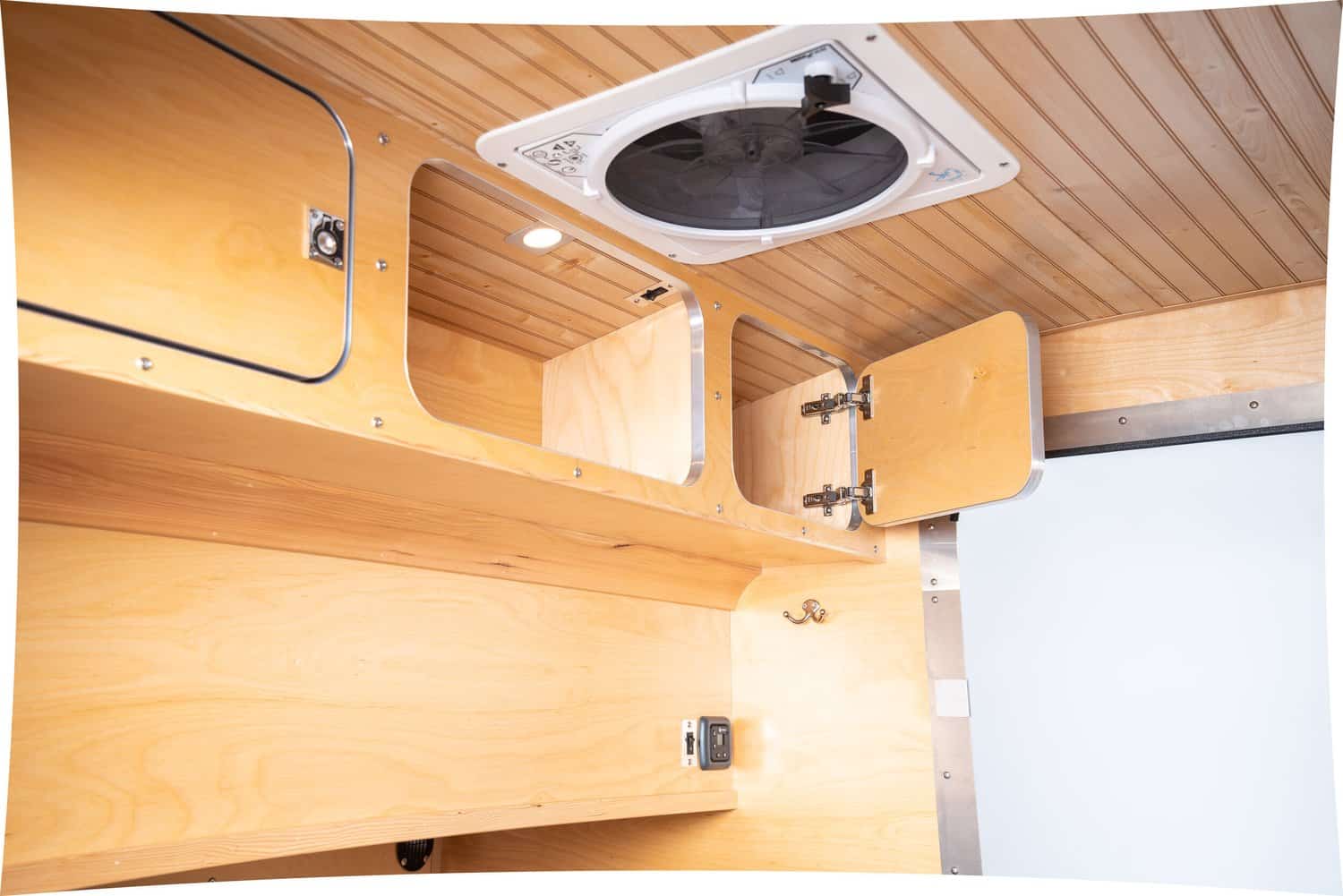 High Camp teardrop cabin with overhead wood cabinets and a Maxxair roof vent