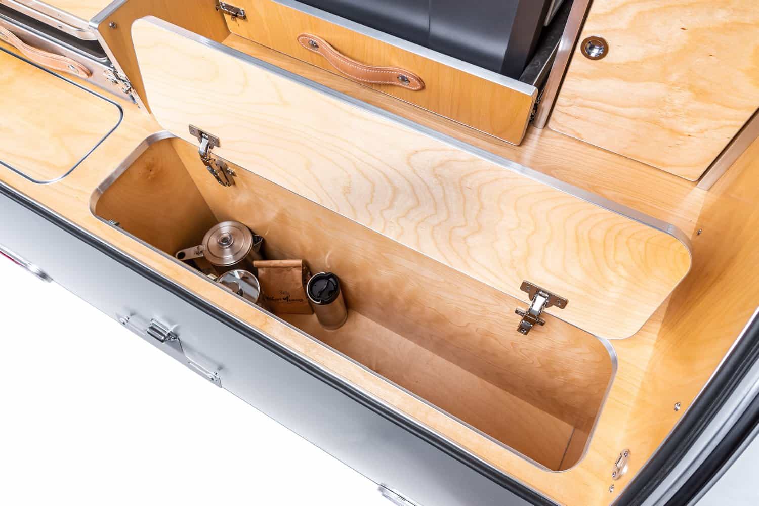 Deep wood storage compartment in the High Camp teardrop galley