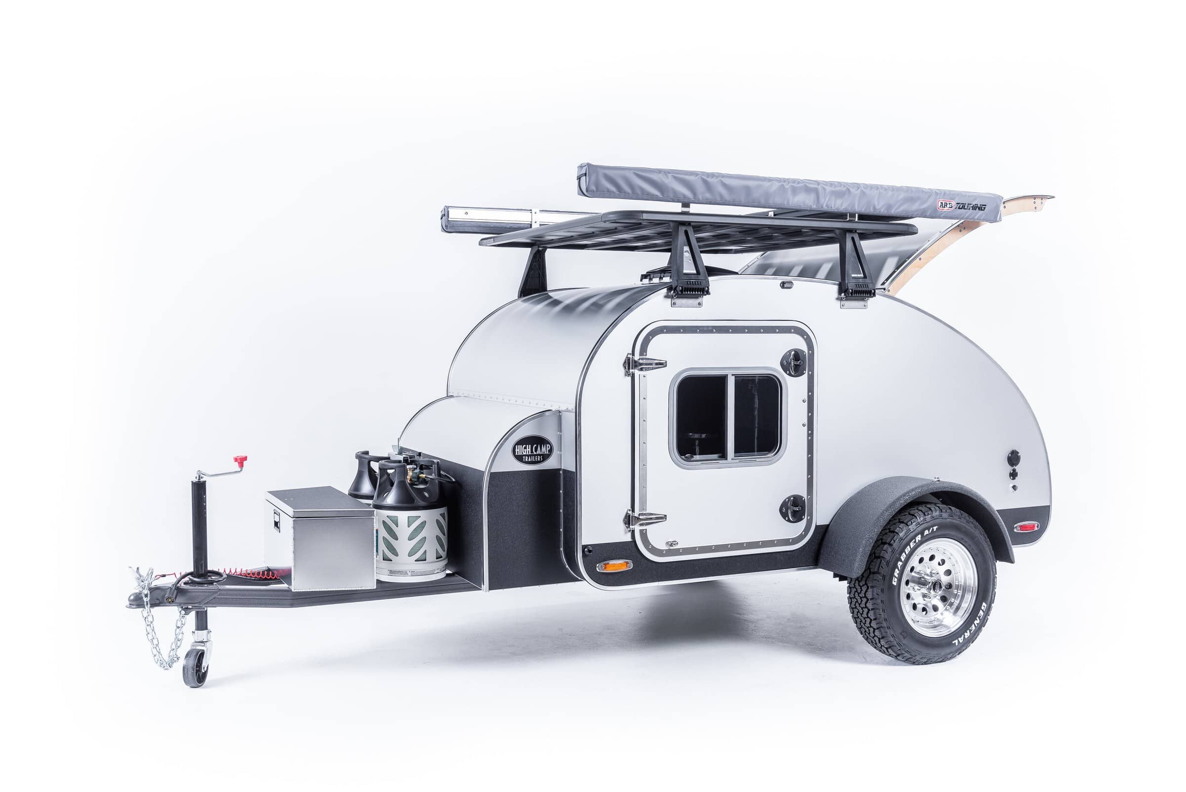 Side studio view of High Camp teardrop with clear anodized aluminum skin and Rhino-lined fenders